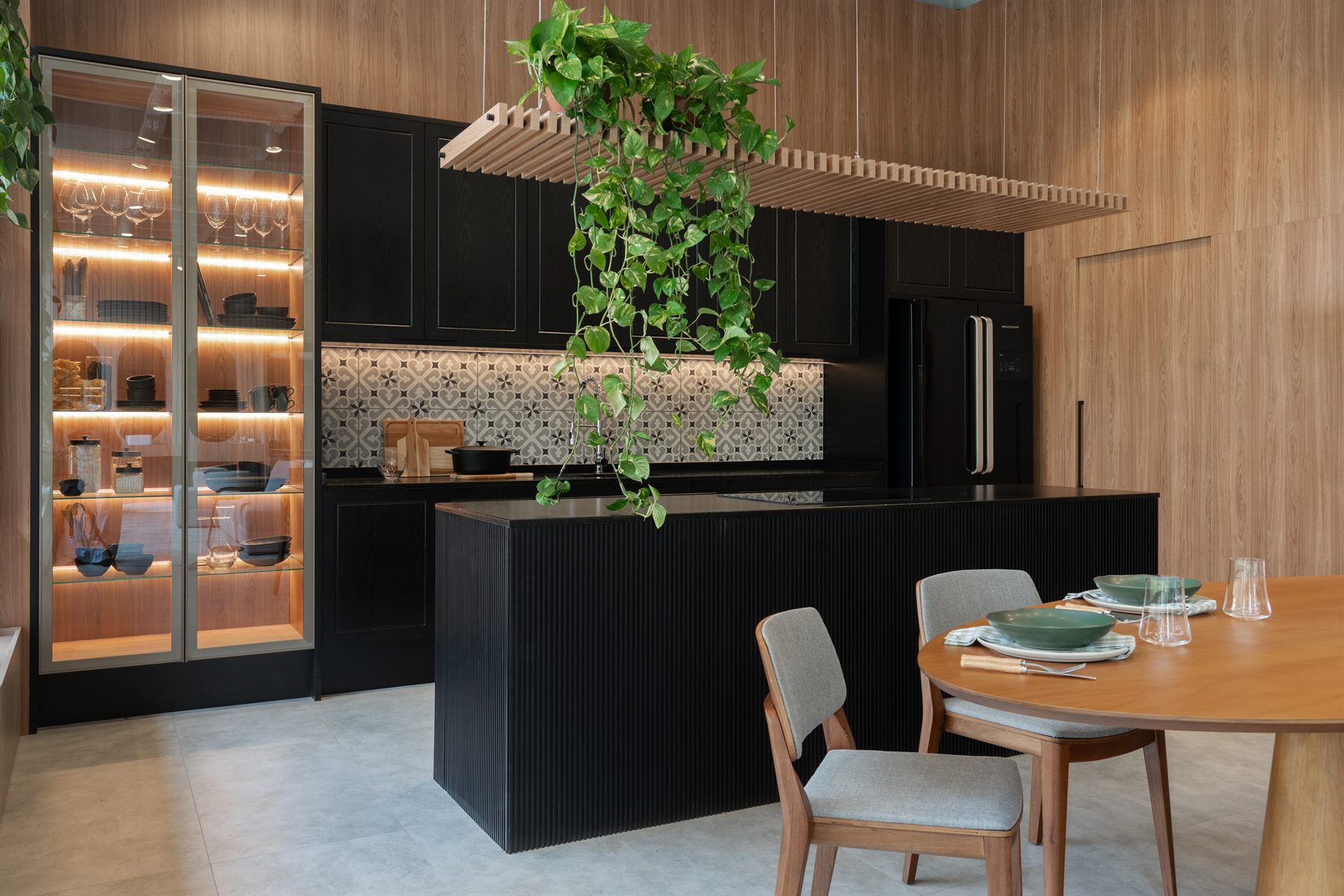 Cozinha gourmet Italínea com ilha escura e cristaleira iluminada